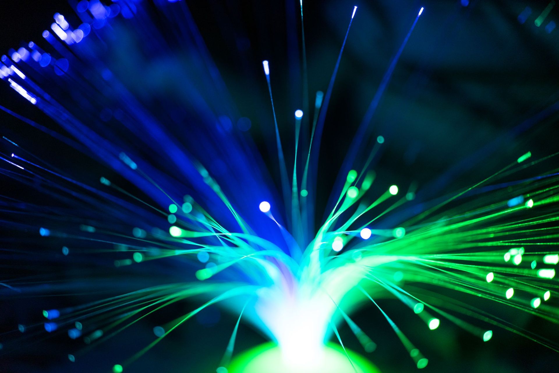 Green and blue fibre-optic strands glowing in the dark